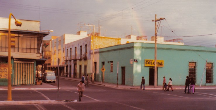 1975.06.01.03 Puebla A rainbow adds more color to an inner-city scene in Puebla, Mexico.